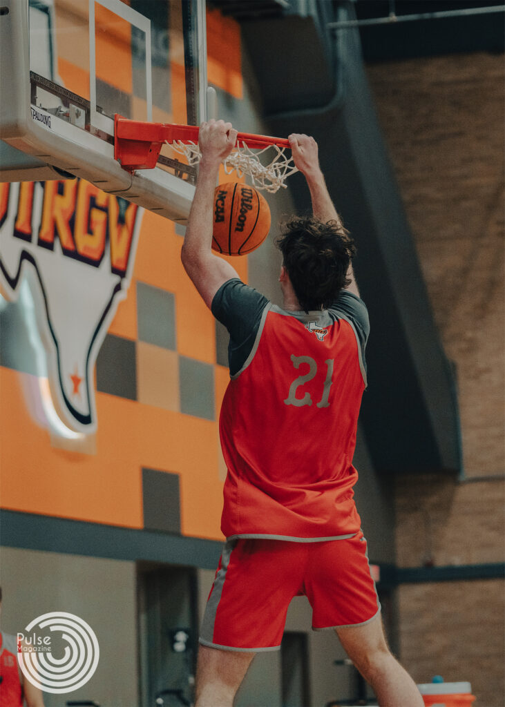 Redshirt sophomore forward Marshal Destremau hangs on the rim after dunking the ball during practice Nov. 1 at the UTRGV Fieldhouse in Edinburg. 
