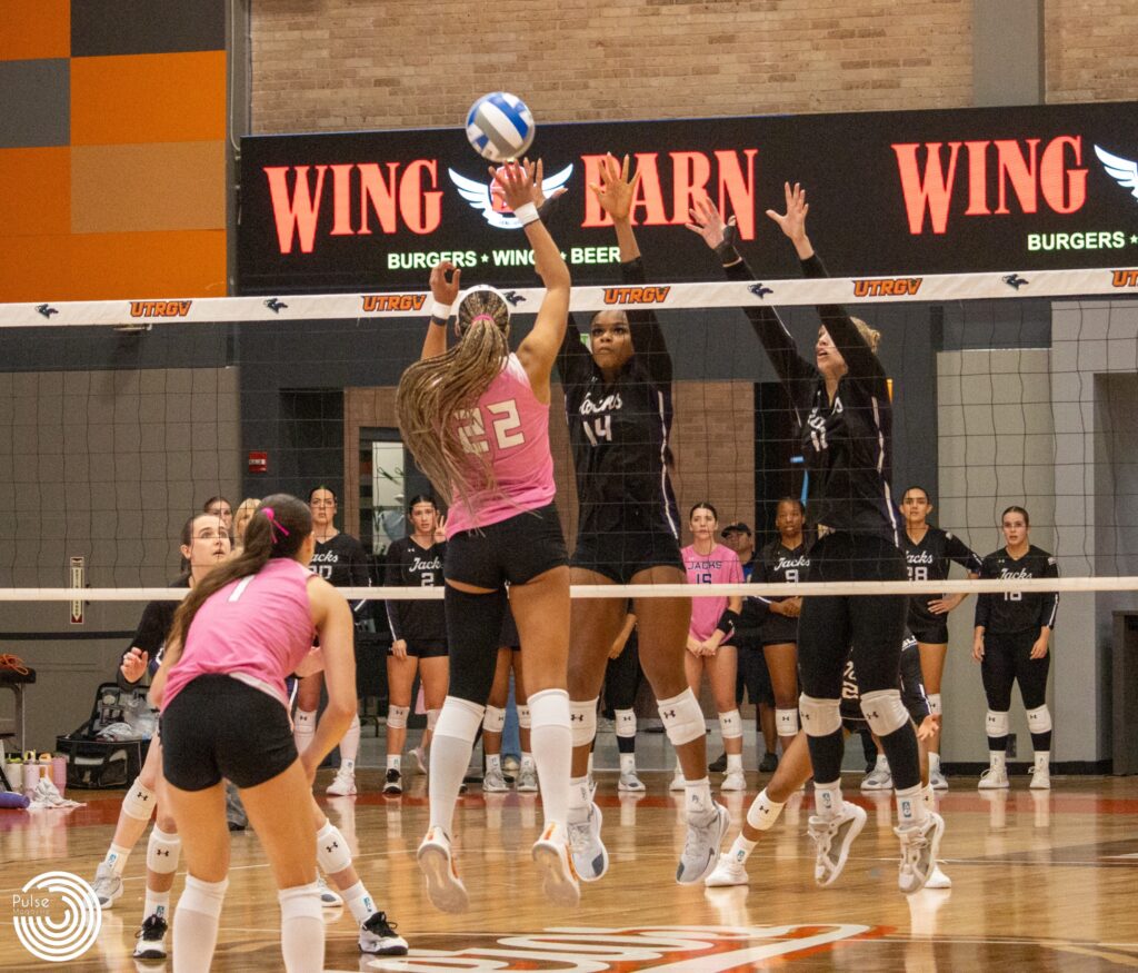 Vaquero middle blocker Julianna Bryant rises above the net to challenge a double-block by Ladyjack middle blockers Jordan Henderson and Caroline Kahled during the third set of the match.